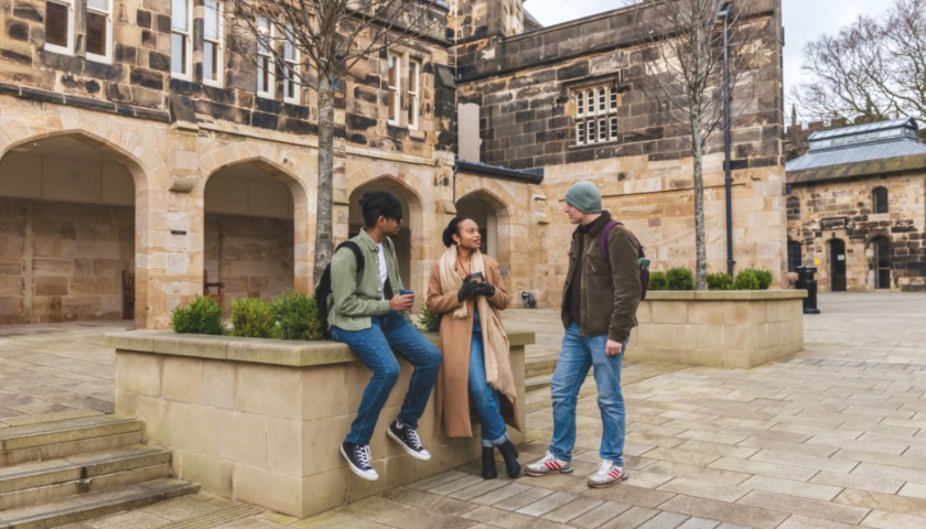 Three students chat in the courtyard of Lancaster Castle