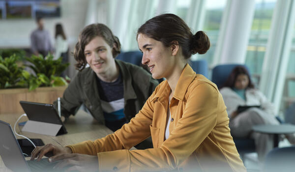 Students sat in front of a laptop