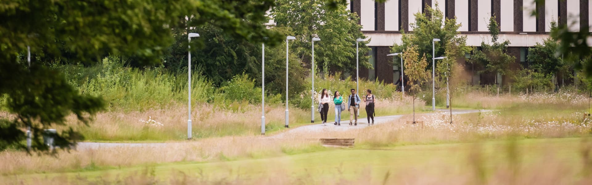 Students walking outside in green space on campus