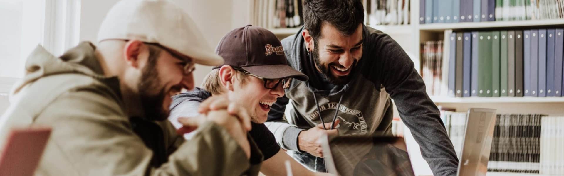 People gathering around a computer in a library