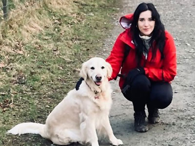Beth crouching with a dog